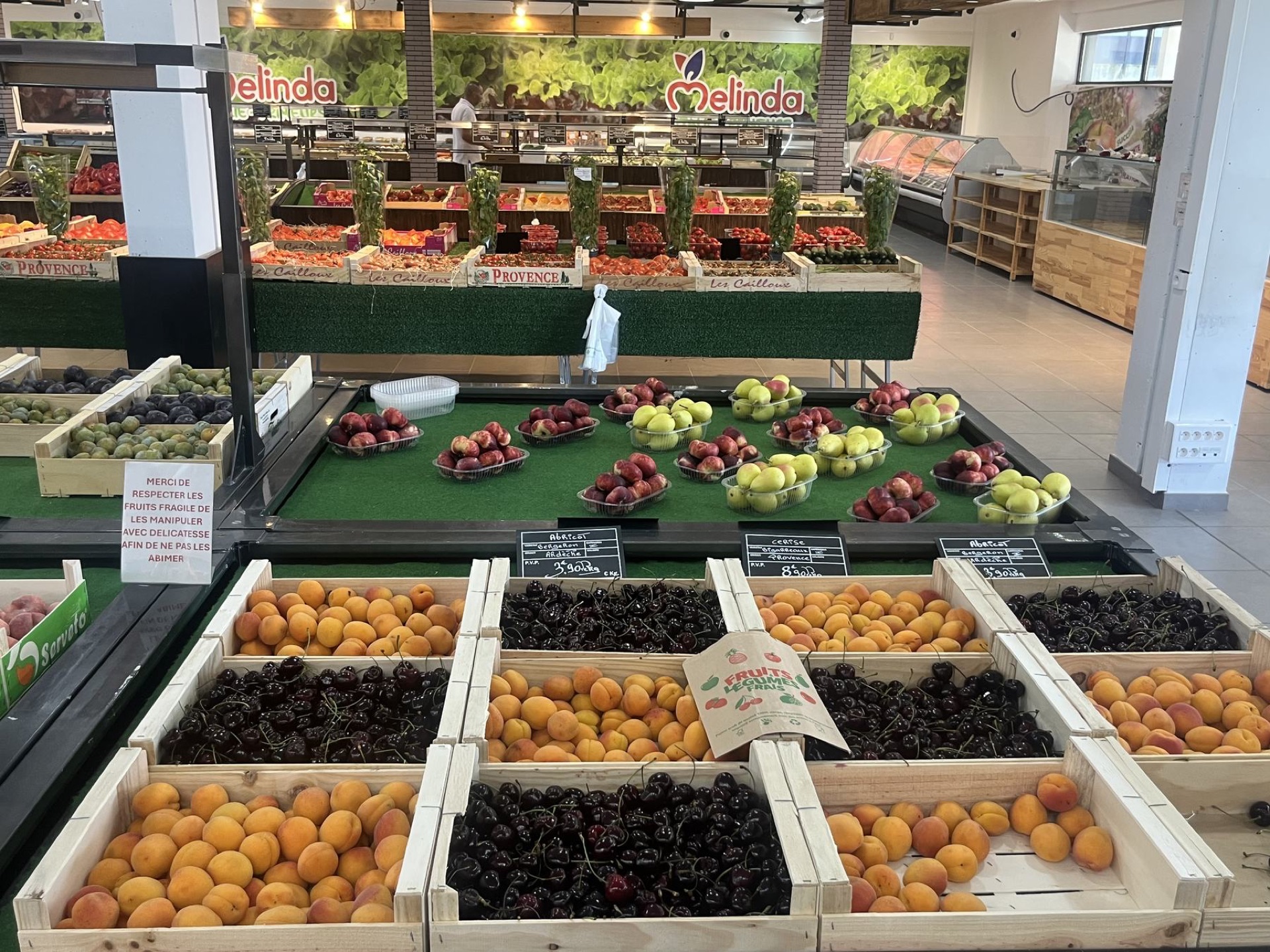 Le magasin Melinda vu de l'intérieur, avec les cagettes de fruits et l'enseigne au fond